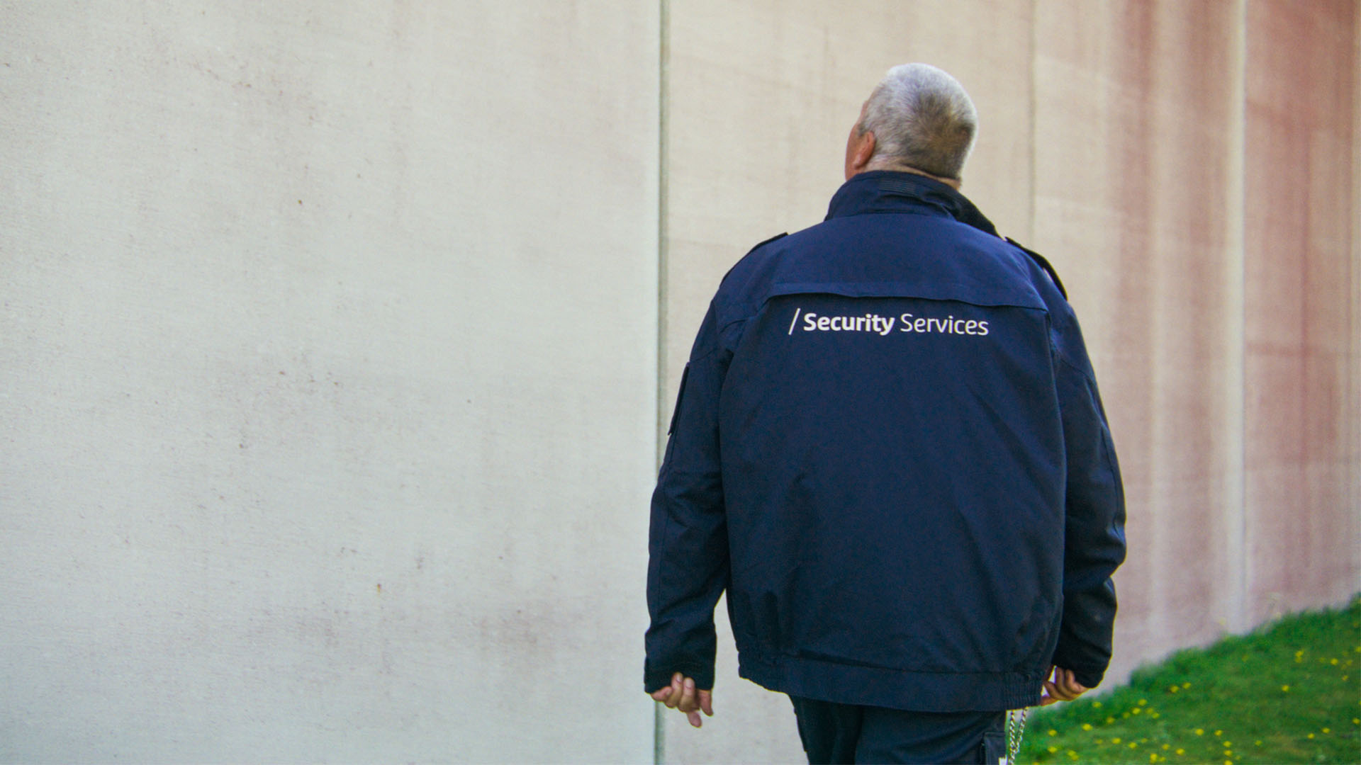 Sicherheitsfachkraft macht Kontrollgang an Mauer
