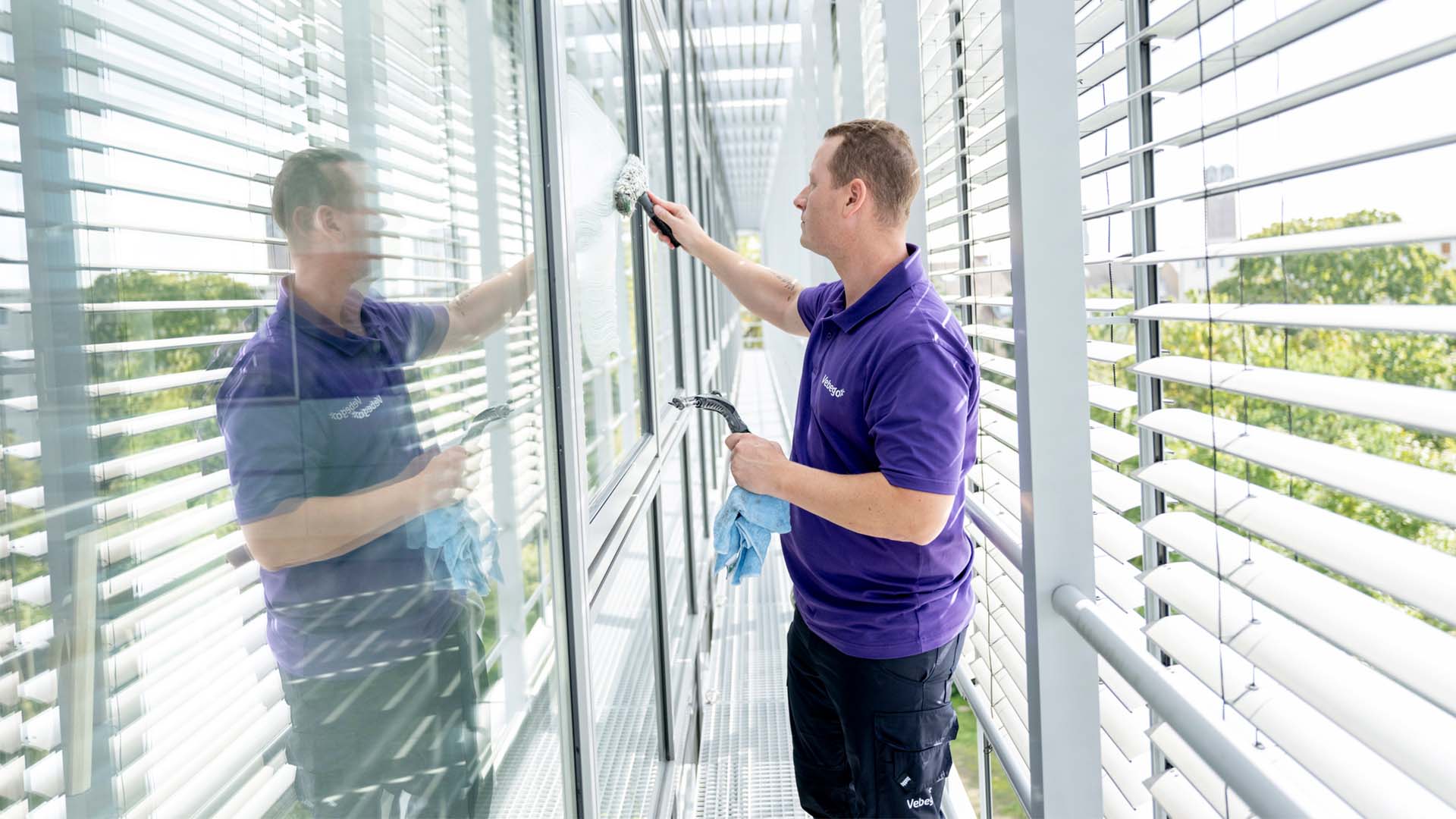 Glasreiniger reinigt Fenster von außen
