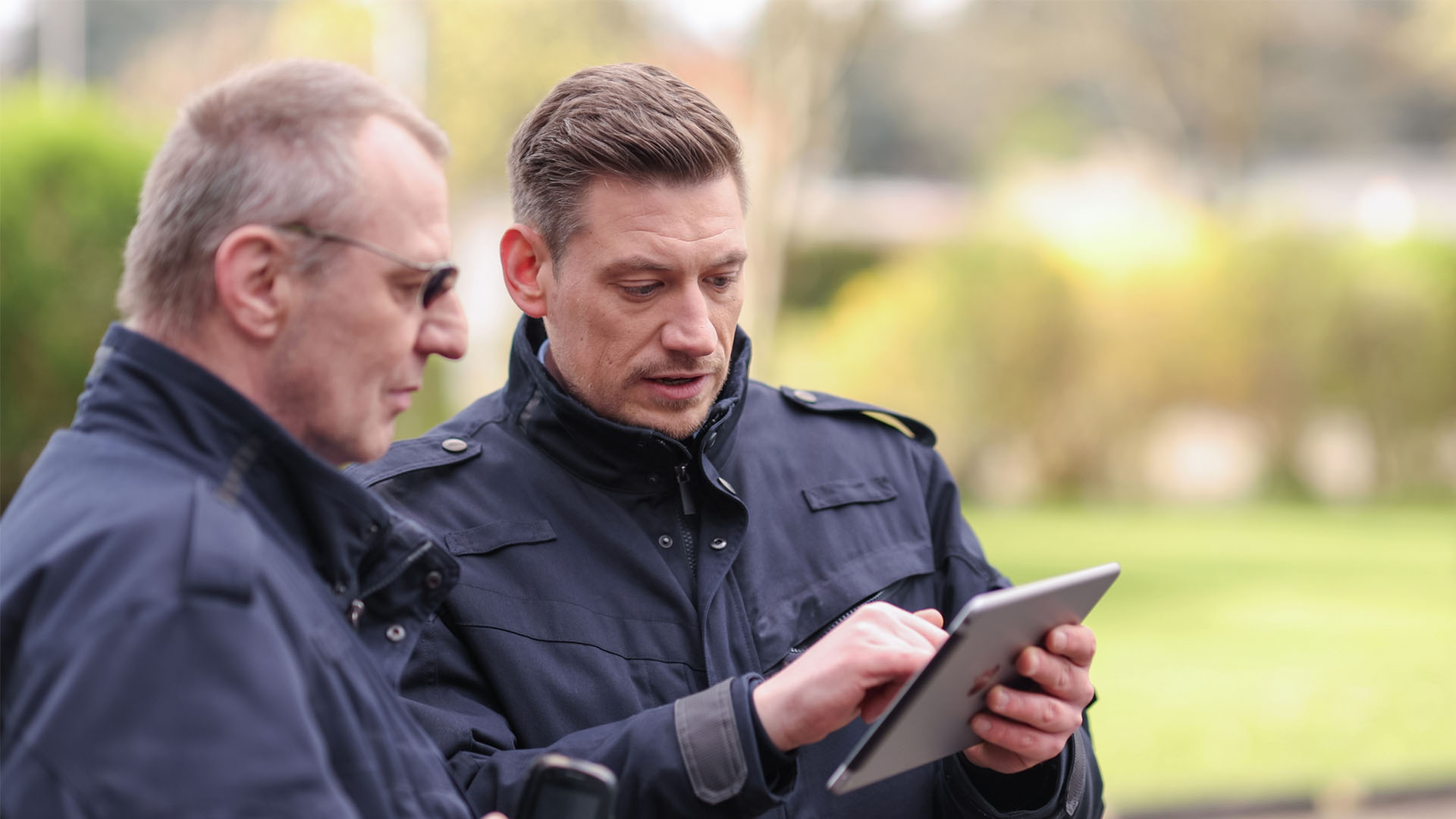 Zwei Sicherheitsfachkräfte mit Tablet
